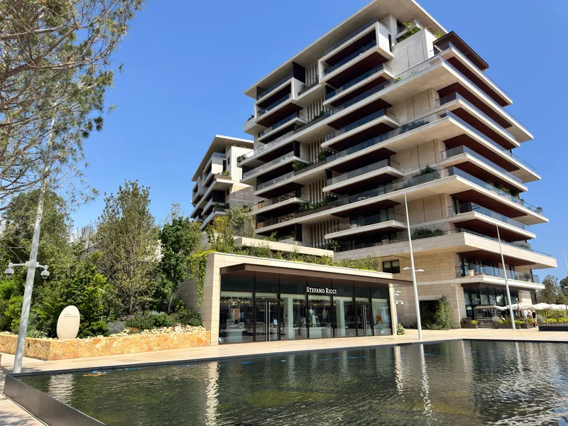 Stefano Ricci luxury boutique at Mareterra viewed across the Le Portier mirrored water feature, with Jardin d'Eau apartments in the background