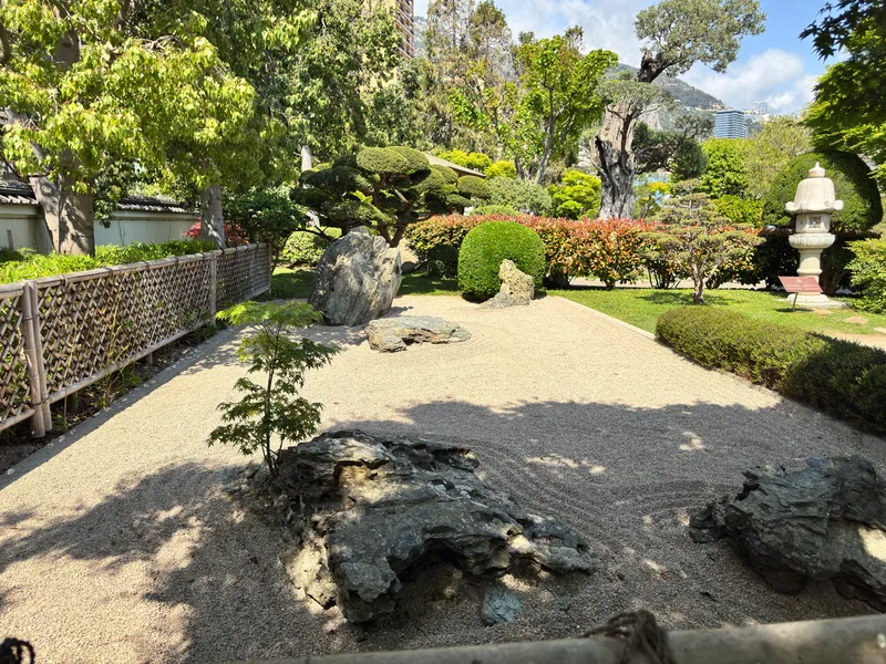 The tranquil Japanese Garden of Monaco with its characteristic stone lanterns, arching pines and reflective water features in the Larvotto district