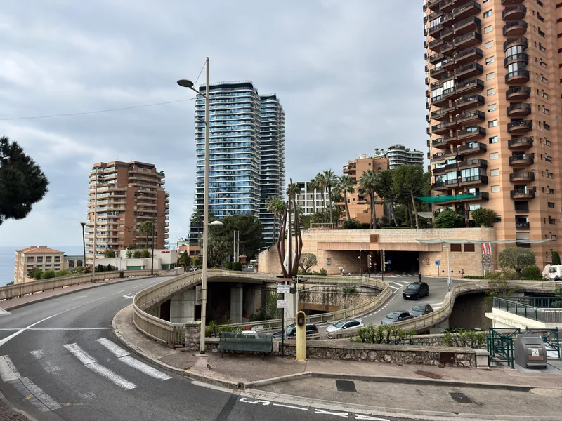 Monaco's iconic border roundabout with the principality's crest at the Roquebrune-Cap-Martin boundary, police present for regular security checks on entering vehicles